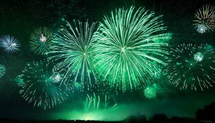 Fototapeta premium green fireworks display on dark sky with sparkling stars