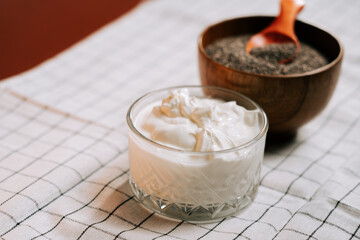 Roasted chia seeds paired with creamy yogurt on a checkered cloth background