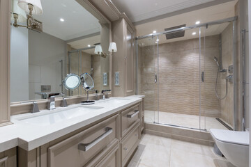 This bathroom showcases a modern design with dual sinks, a large glass shower, and stylish cabinetry. Soft lighting enhances the serene atmosphere, perfect for relaxation.