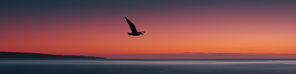 Silhouette of bird flying over ocean during vibrant sunset