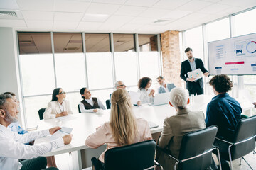 Collaborative business team discussing financial progress during a formal meeting in a modern office setting