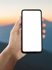 Hand holding smartphone on mountain background, scenic outdoor landscape with blue sky and peaks, travel and adventure concept, mobile photography or navigation app idea, exploring nature with technol