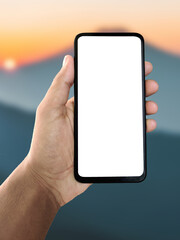 Hand holding smartphone with sunset view in background, meditation or tourism app on screen, peaceful evening landscape, mindfulness and travel concept, mobile relaxation and vacation technology idea