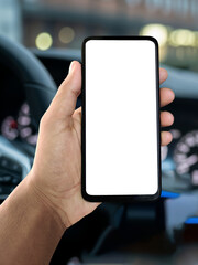 Hand holding smartphone with car interior in background, modern vehicle dashboard and steering wheel visible, mobile navigation or driving app concept, technology and transportation lifestyle photo