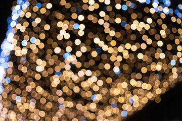 Bokeh of holiday garland lights on the city street creating festive atmosphere.