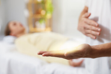 Obraz premium Reiki master showing aura in his hand during therapy indoors, closeup