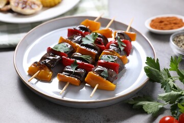Skewers with tasty grilled vegetables served on grey table, closeup