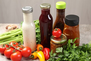 Bottles of different tasty sauces and products on grey table, closeup
