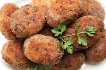 Tasty meat patties with parsley on plate, closeup