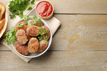 Tasty meat patties served on wooden table, flat lay. Space for text