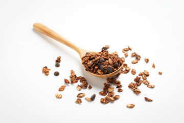 Delicious granola with chocolate chips in spoon on white background, closeup