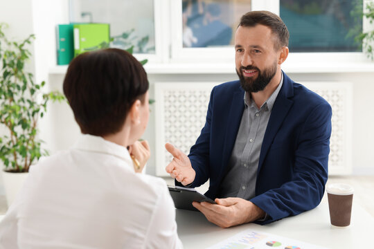Business process. Colleagues working together at desk in office