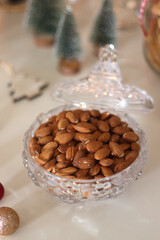 Cookie jar, tea, wine, nuts, books, lit candles and Christmas decorations on the table. Cozy Christmas hygge at home. Selective focus.