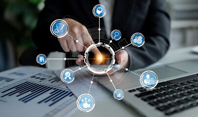 A business professional interacts with a smartphone amidst digital icons representing technology,...