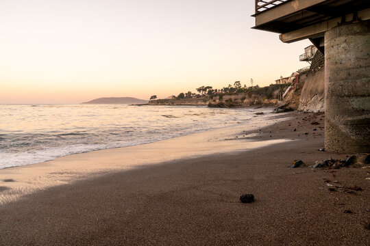 Sunset Reflections on a Tranquil Coastal Beach with Pier