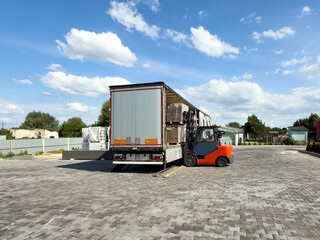 Rear view of forklift loading pallets into truck