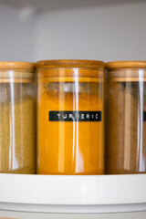 Neatly organized labeled food pantry in a home kitchen with spices grains flour rice sugar nuts