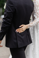 Close-up of the bride holding the groom's arm