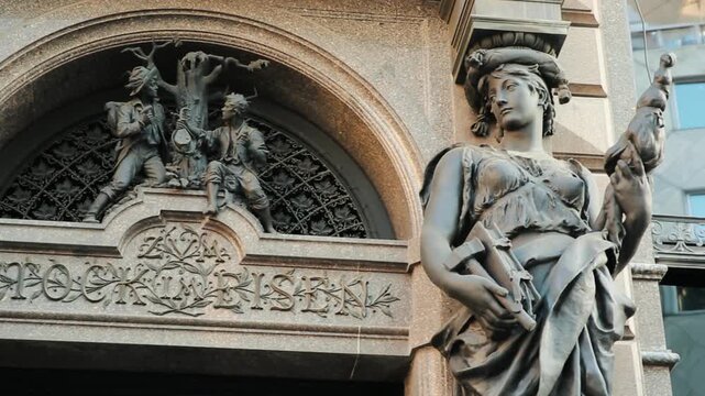 Detailed close-up of an ornate Art Nouveau residential in Vienna. The Secession-style building features sculpted details, curved balconies, and intricate stucco work under a blue sky.