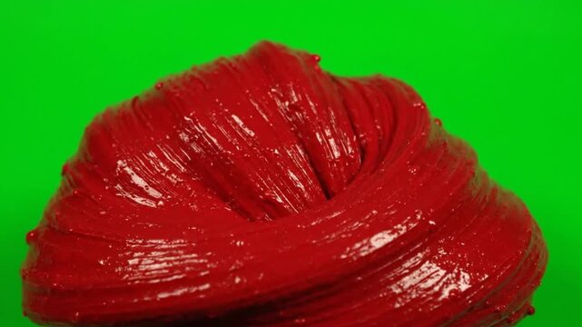 Vibrant red slime texture moves dynamically against a green screen background