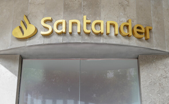 Seville, Spain; October 15, 2025: Santander bank branch gold logo sign on facade.