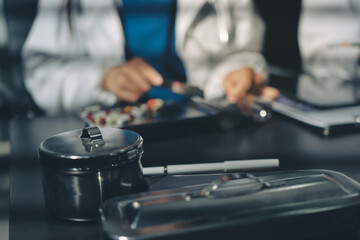 Two doctors and a female nurse meet at a table in the hospital, collaborating on medical tasks using laptops and computers