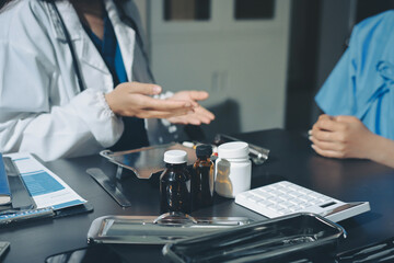Female doctor holding a medicine bottle is checking the quality of medicine for any side effects the patient or not and recording patient information at the hospital. medical and health care concept