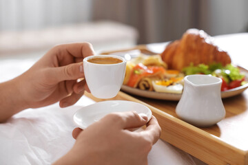 Man having breakfast in bed, closeup. Hotel room service