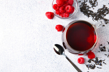 Delicious tea, raspberries and brew served on light table, flat lay. Space for text