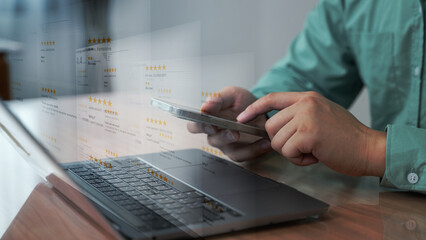 Close-up of a person browsing customer reviews and star ratings on a smartphone with a laptop on a desk, indicating e-commerce research.
