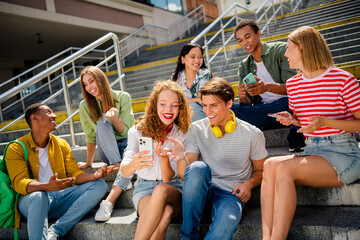 Group of young friends sitting on outdoor stairs enjoying time together showing a joyful and friendly atmosphere