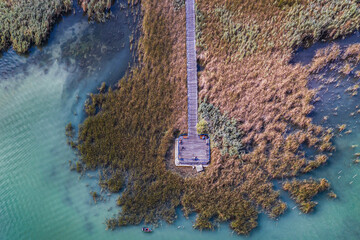 Wooden pier stretching into autumn reeds on Lake Balaton
Aerial view of a wooden pier surrounded by...