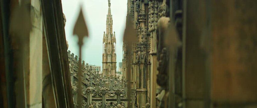 Ornate gothic stonework details atop Duomo di Milano cathedral in Italy