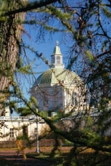 View of the dome of Grand Menshikov Palace in Oranienbaum through autumn branches on a clear sunny day.