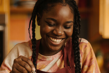 Young woman cooking and smiling in a warm kitchen