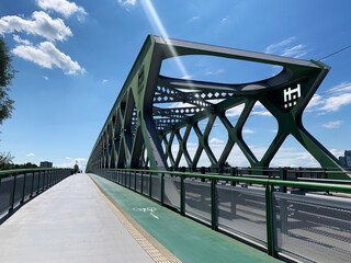 The Old Bridge, Bratislava. Cityscape of bike path, pedestrian walkway, and tramway. Green cantilevered iron structure. Architecture, transportation. Traveling in Slovakia. Clear sky. Photography
