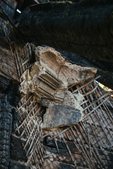 Close-up of a burned wall showing blackened wood, exposed lath structure, and crumbling plaster after a destructive fire in an old house.