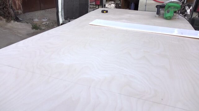 worker measures board for cutting