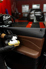 Hand applied foaming detail uses a detailing brush and cleaning solution to remove grime from every car door panel safely. Foaming on the detailing brush.