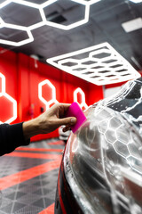 Detailer use squeegee tool to smooth headlight protection film. Headlight protective film...