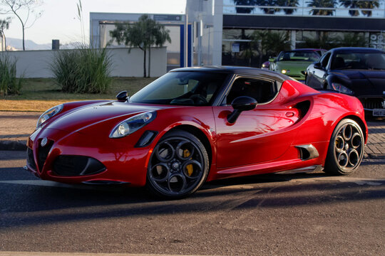 Red Alfa Romeo 4C front view three quarters, exotic italian sportscar in motion