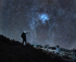 Fototapeta premium Astrophotography of Man on Mountain and Pleiades - Night landscape