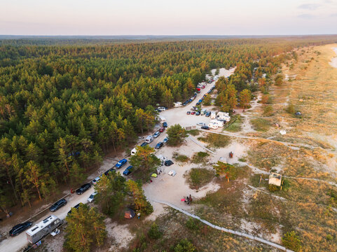 Early morning drone view of Estonia's popular Perakula campsite, crowded with campers and RVs in a pine forest during peak season.