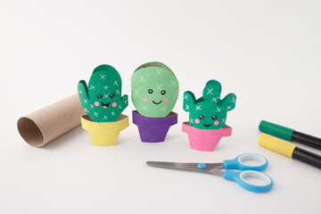 DIY cactus craft using toilet paper rolls with scissors and markers, ideal for schools, teachers, educational blogs, and childhood development platforms focused on creativity and recycling,