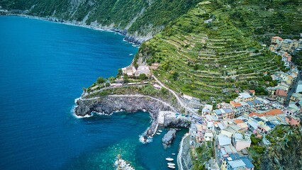 Naklejka premium Drone oblique of Manarola’s tiny harbor, terraced vineyards and open Ligurian Sea framed by steep headland, Cinque Terre, Italy