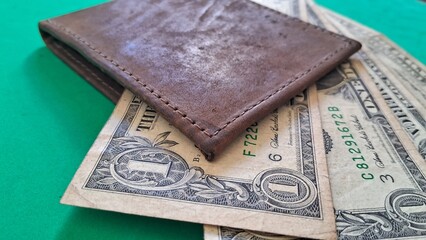 Brown Leather Wallet and US Dollar Bills on Green Surface