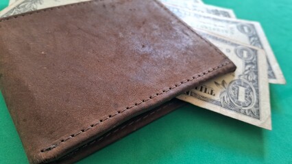 Brown Leather Wallet and US Dollar Bills on Green Surface