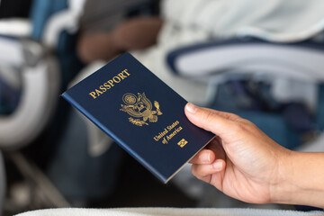 Travelers passenger hand holding USA passport sitting on airplane 	