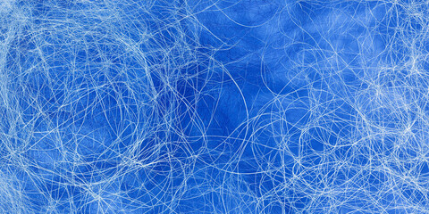 Dense web of white tangled lines on vivid blue background forming abstract net texture
