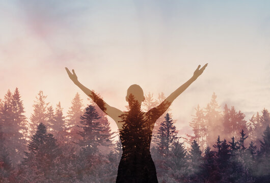 Young joyful woman outdoors with arms up to the sky finding inner strength peace in nature 